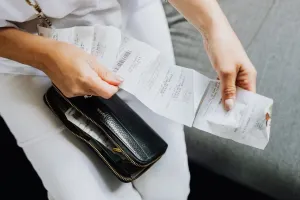 Laptop z kalkulatorem wynagrodzeń na biurku obok pln, notatnika i długopisu, w tle rozmyte domowe biuro.