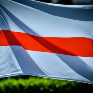 Smartfon z kolorowym przelicznikiem walut euro na złotówki na biurku, obok monety i banknot euro w domowym biurze.